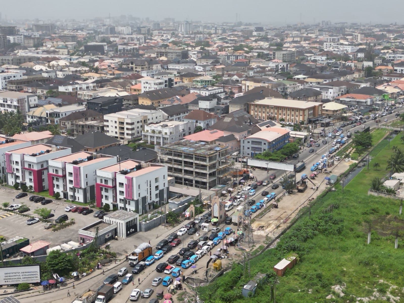 Aerial view of a dense Lagos neighbourhood of houses and apartment blocks beside a busy road